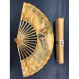 A BOXED FAN WITH MOTHER OF PEARL STICKS, THE PAPER LEAF PAINTED WITH A GARDEN GATHERING OF 18th C.