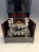 A 19th C. FRENCH EBONISED DECANTER BOX, THE LID LIFTING UP TO REVEAL FOUR ENGRAVED GLASS DECANTERS
