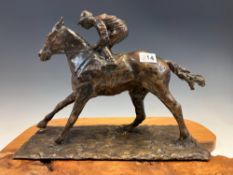 A 20th C. BRONZE HORSE WITH THE JOCKEY CROUCHING IN THE STIRRUPS, THE RECTANGULAR BASE. W 33cms.