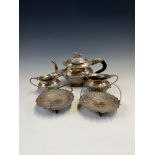 AN INDIAN WHITE METAL THREE PIECE TEA SET TOGETHER WITH A PAIR OF SWEETMEAT DISHES, THE OVERSWINGING