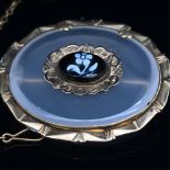 AN ANTIQUE CHALCEDONY OVAL BROOCH WITH A CARVED FLORAL CAMEO TO THE CENTRE, MOUNTED IN A