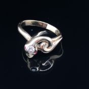 A 20th CENTURY STYLISED COILED SERPENT RING SET WITH A DIAMOND SET HEAD AND RUBY EYE. FINGER SIZE R.