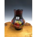 A WILLIAM MOORCROFT GRAPE PATTERN VASE, THE VINE LEAVES IN AUTUMNAL COLOURS. H 22.5cms.