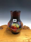A WILLIAM MOORCROFT GRAPE PATTERN VASE, THE VINE LEAVES IN AUTUMNAL COLOURS. H 22.5cms.