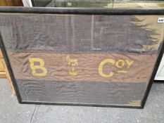 A FRAMED HAND PAINTED BANNER INSCRIBED ON THE RED CENTRAL BAND B COY ABOVE THE CENTRAL LION ON A