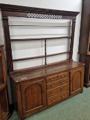 A 19th C. OAK DRESSER, THE OPEN BACK OF THREE SHELVES BETWEEN FLUTED PILASTERS, THE BASE WITH FOUR