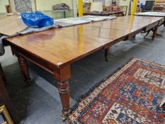 A NEAR PAIR OF 19th C. MAHOGANY DINING TABLES RACKING OUT TO TAKE LEAVES, THE SQUARED END ON TURNED