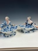 A PAIR OF MEISSEN ONION PATTERN FIGURAL SWEETMEATS, THE BOWLS HELD RESPECTIVELY BY A RECLINING MAN