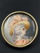 A HANDPAINTED PORTRAIT MINIATURE IN A ROUND BROOCH SETTING, UNMARKED ASSESSED AS 14ct GOLD. DIAMETER