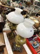 TWO BRASS OIL LAMPS, STORM FUNNELS AND MILK GLASS SHADES