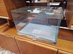 A GLASS AND CHROME TABLE TOP DISPLAY CASE LABELLED FOR MICHAEL KORS