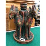 AN EASTERN CARVED WOOD HORSE CANDLE STAND.