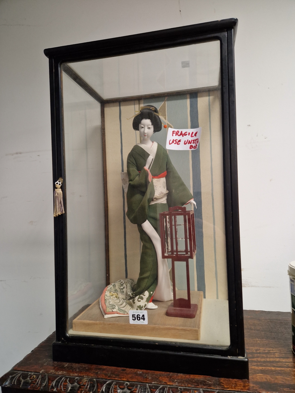 A JAPANESE DOLL IN A GLAZED CASE