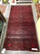 AN AFGHAN RUG. 240 x 124cms TOGETHER WITH A SMALL BELOUCH PRAYER RUG (2)