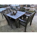 A TEAK GARDEN TABLE WITH FOUR MATCHING CHAIRS.