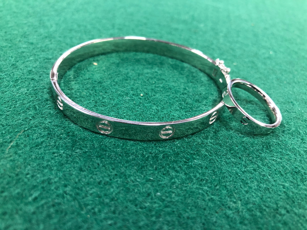 A SILVER HINGED LOVE BANGLE AND MATCHING RING, WITH SCREW DECORATION.