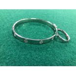 A SILVER HINGED LOVE BANGLE AND MATCHING RING, WITH SCREW DECORATION.