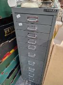 A BISLEY TEN DRAWER METAL FILING CABINET CONTAINING SOME TOOLS AND CLOCK PARTS