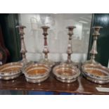 A SET OF FOUR PLATE ON COPPER CANDLESTICKS TOGETHER WITH TWO PAIRS OF WINE COASTERS