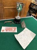 A SMALL FILIGREE HINGED LID BOX, A SILVER TROPHY CUP, POCKET KNIFE AND A TEN SHILLING NOTE.