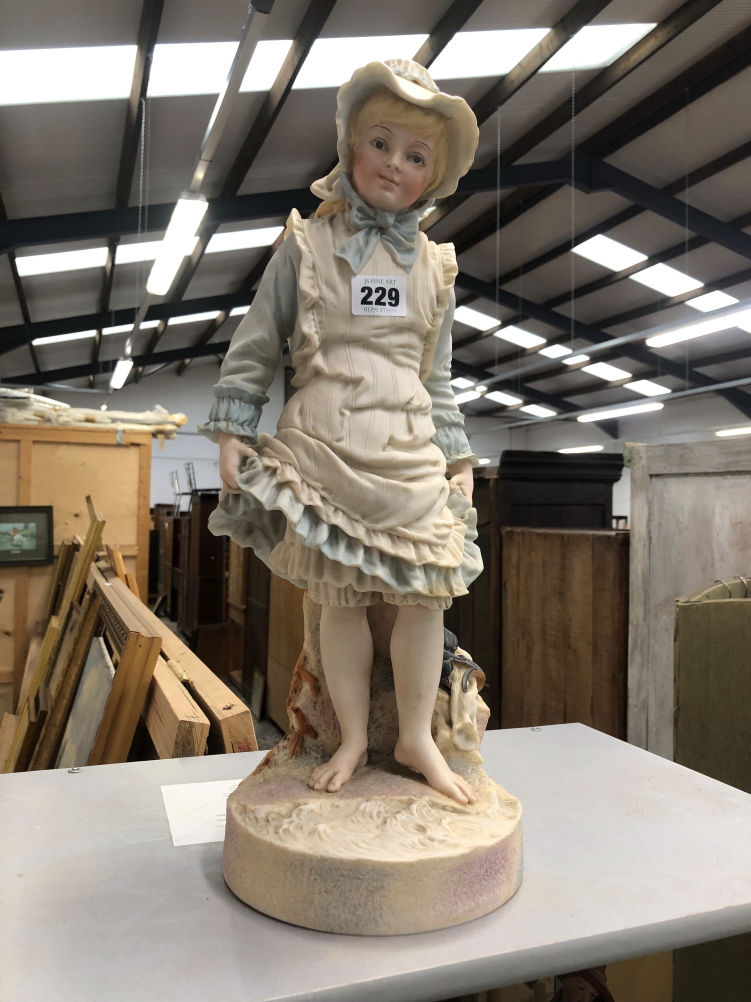 A TINTED PARIAN FIGURE OF A GIRL ABOUT TO PADDLE