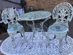 A GREEN PAINTED CAST ALLOY PATIO TABLE WITH TWO MATCHING CHAIRS
