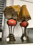 A PAIR IOF TABLE LAMPS WITH TERRACOTTA BUN SHAPED BOWLS SUPPORTED ON THREE BRASS ARMS