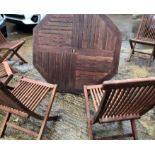 AN OCTAGONAL TEAK FOLDING GARDEN TABLE WITH SIX MATCHING CHAIRS.