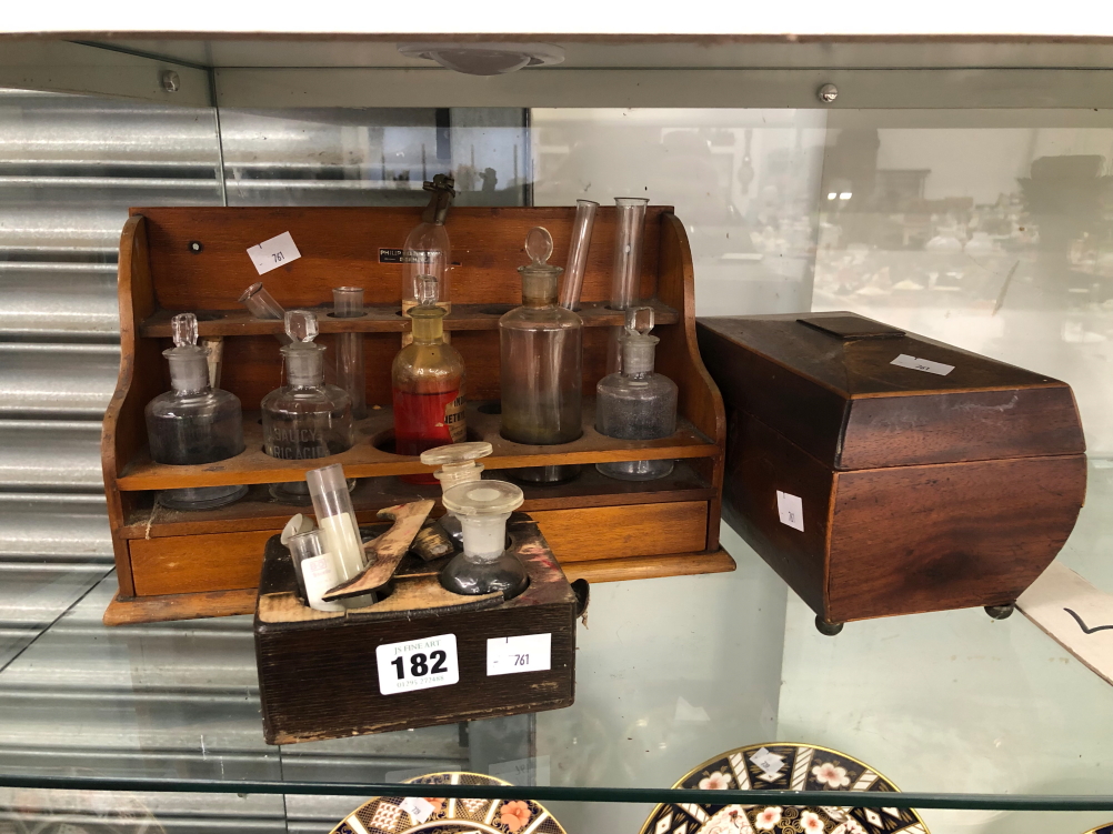 A COLLECTION OF CHEMISTRY BOTTLES IN TWO WOOD STANDS TOGETHER WITH A MAHOGANY TEA CADDY