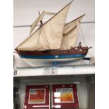 A WOODEN MODEL SHIP IN FULL SAIL WITH A BLUE AND WHITE HULL