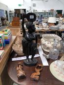 AN AFRICAN BLACK HARD WOOD FIGURE OF A LADY TOGETHER WITH TWO SMALLER FIGURES IN PALER WOOD