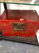 A CHINESE RED LACQUER TWO HANDLED TRUNK GILT WITH CHILDREN AT PLAY