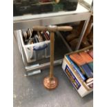 A COPPER WASHING DOLLY WITH A WOODEN T BAR HANDLE