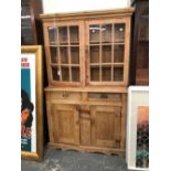 AN ANTIQUE PINE DRESSER WITH GLAZED CABINET OVER.