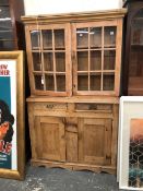 AN ANTIQUE PINE DRESSER WITH GLAZED CABINET OVER.