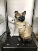 A WINSTANLEY POTTERY SIAMESE CAT TOGETHER WITH A WHITE CAT