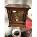 AN OAK CASED MANTLE CLOCK STRIKING ON A COILED ROD