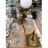 A BRASS OIL LAMP, A BRASS HOT WATER CAN, A CHAMBERSTICKS, TWO KITCHEN SCALES AND FOUR DECANTERS.