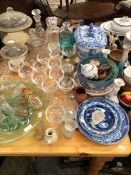 A BLUE AND WHITE POTTERY SOUP TUREEN, PLATES, DECANTERS, CHAMPAGNE GLASSES, GLASS TRUMPET CENTRE