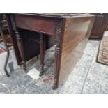 A 19th C. MAHOGANY DROP FLAP DINING TABLE ON REEDED LEGS TAPERING TO CERAMIC CASTER FEET.