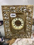 A BRASS EASEL BACK DESK CLOCK IN A FLORAL DECORATED OPEN WORK FRAME WITH BALANCE WHEEL ESCAPEMENT.