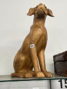 A LARGE CARVED WOODEN SEATED DOG.