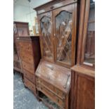 AN OAK BUREAU BOOKCASE WITH LEAD GLAZED DOORS