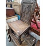 AN ANTIQUE CARVED OAK HALL CHAIR