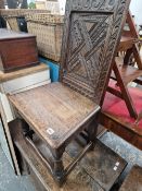AN ANTIQUE CARVED OAK HALL CHAIR