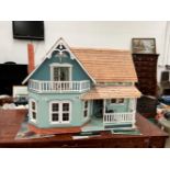 A DOLLS HOUSE WITH A WOODEN SHINGLE ROOF AND ELECTRIC LIGHT