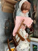 A DOLL IN A PRAM TOGETHER WITH A BLACK DOLL IN A ROCKING CHAIR