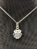 A TWO COLOUR GOLD STONE SET SPIDER PENDANT,ON AN 18ct HALLMARKED GOLD CURB CHAIN. THE PENDANT