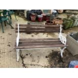 A GARDEN BENCH WITH CAST IRON WHITE PAINTED ENDS