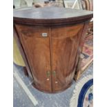 A GEORGIAN MAHOGANY BOW FRONT CORNER CABINET